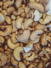 Close-up of roasted cashew nuts ready for packaging with natural earthy tones.