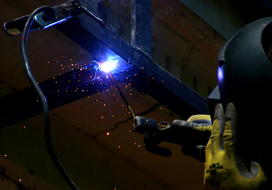Skilled welder creating arc during metal fabrication with bright welding sparks