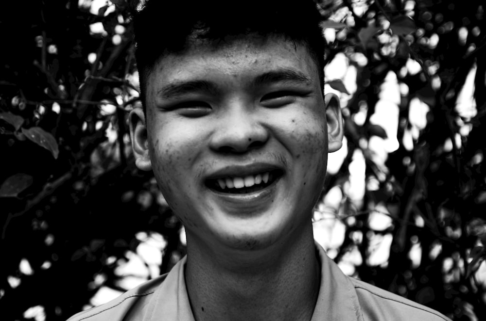 a black and white photo of a man smiling