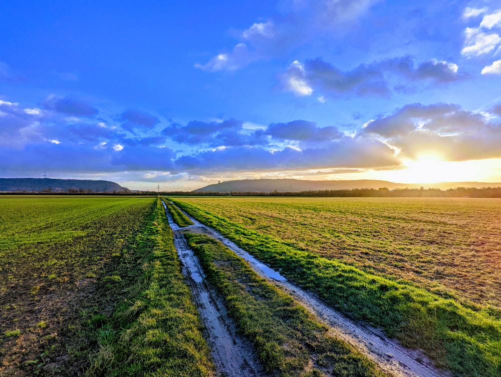 the sun is setting over a large field