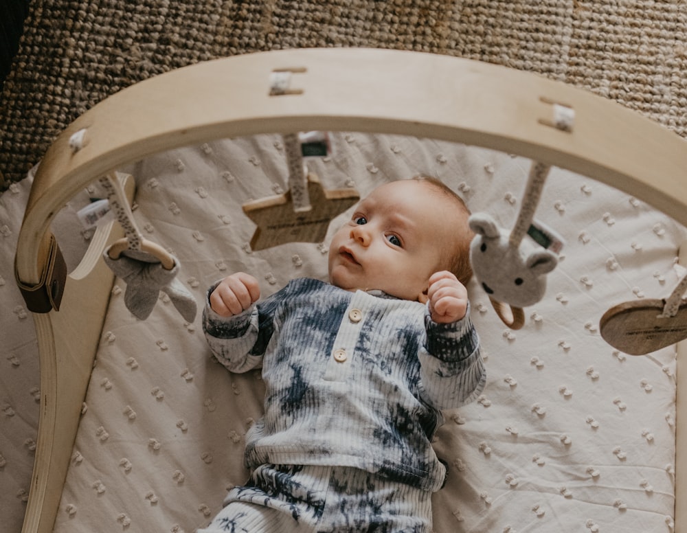 a baby laying in a crib with a stuffed animal