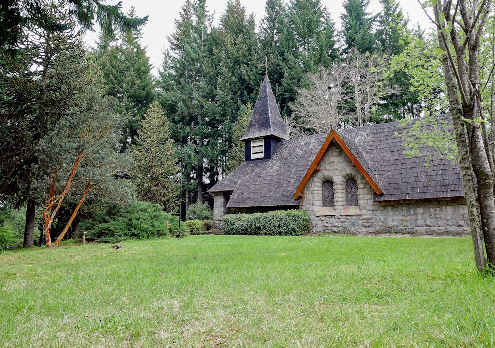 a small church with a steeple in the middle of a field