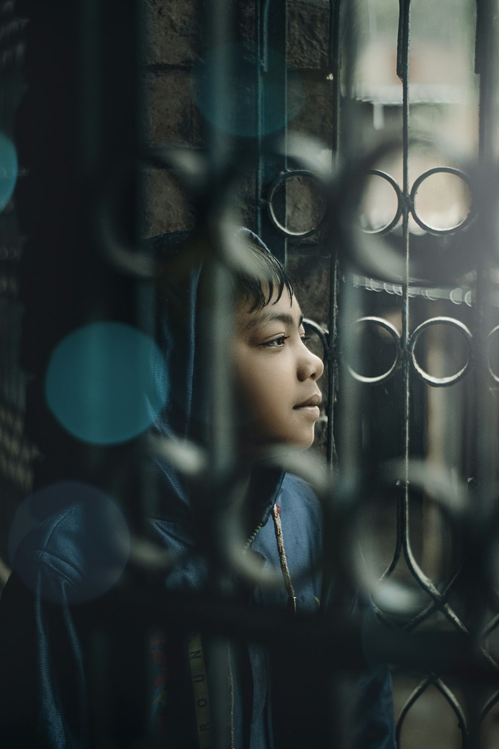 a young boy is looking out of a window