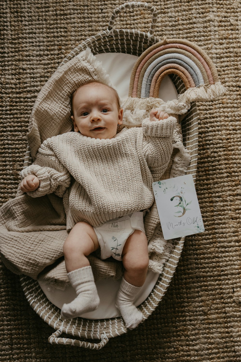 a baby is laying in a basket with a book