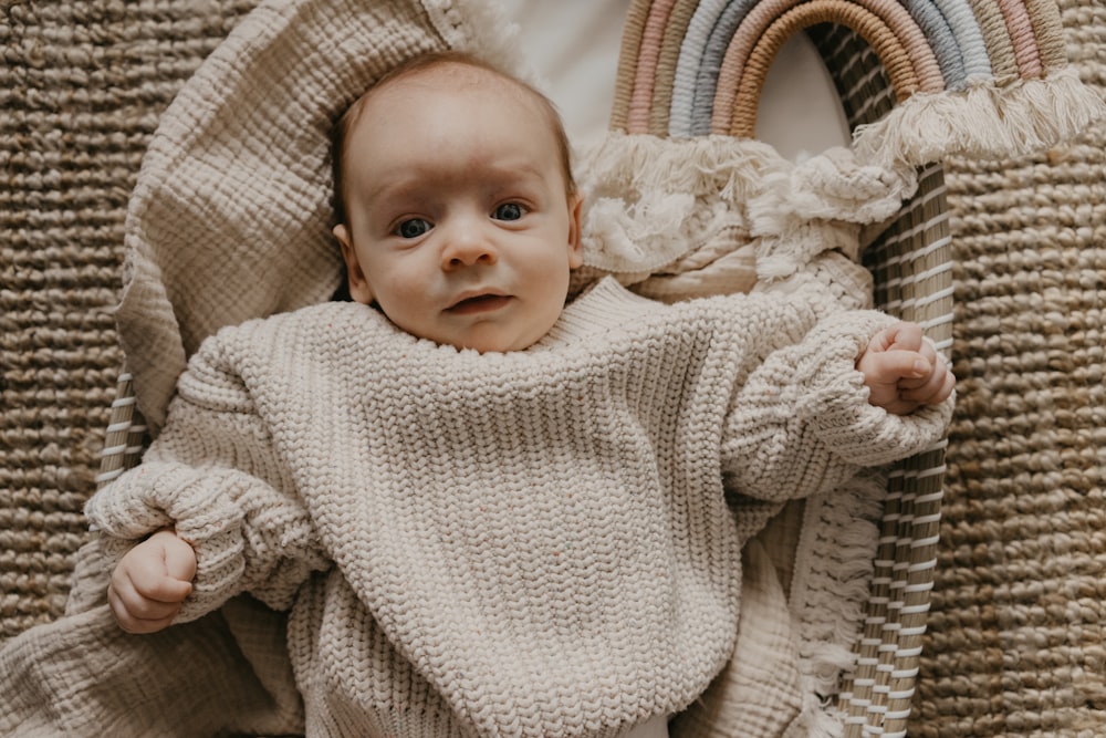 a baby laying in a wicker chair