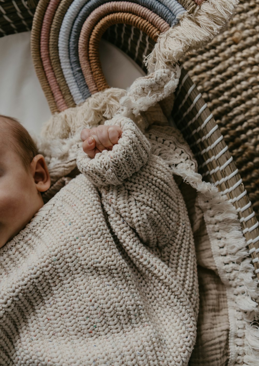 a baby wrapped in a blanket on top of a wicker basket