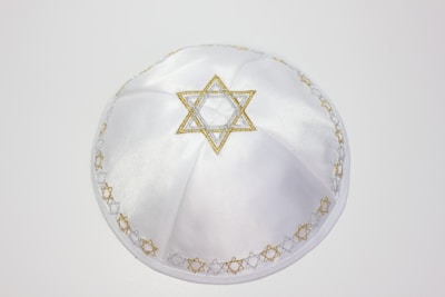 a white hat with a gold star of david on it
