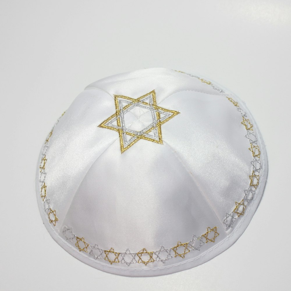 a white hat with a gold star of david on it