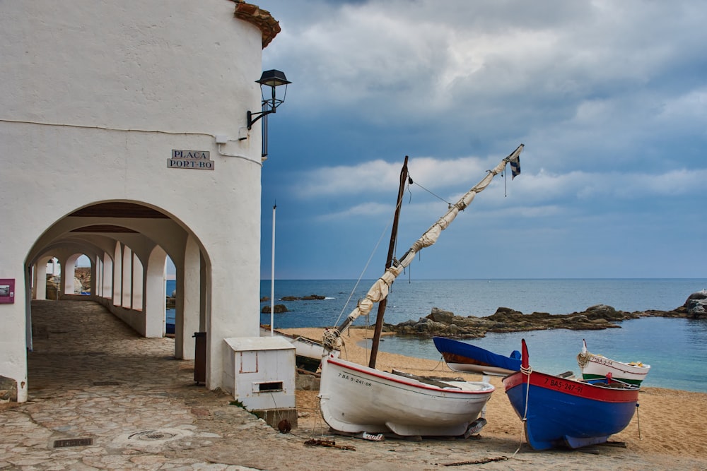 a couple of boats sitting on top of a sandy beach