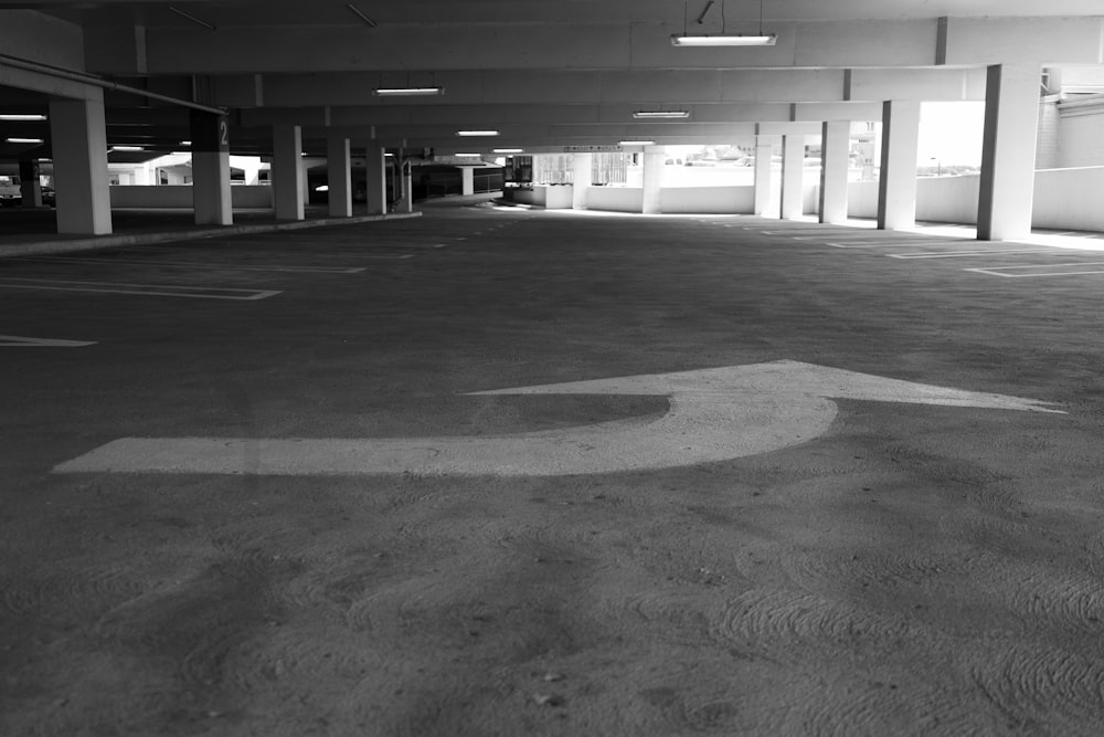 an empty parking garage with a sign painted on the floor