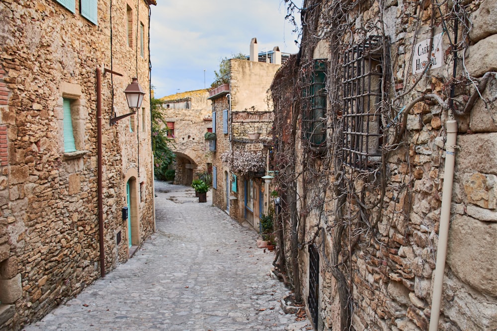 a narrow cobblestone street lined with stone buildings