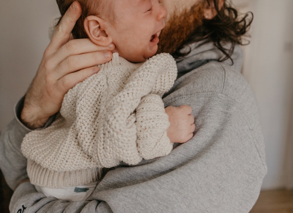 a man holding a baby in his arms