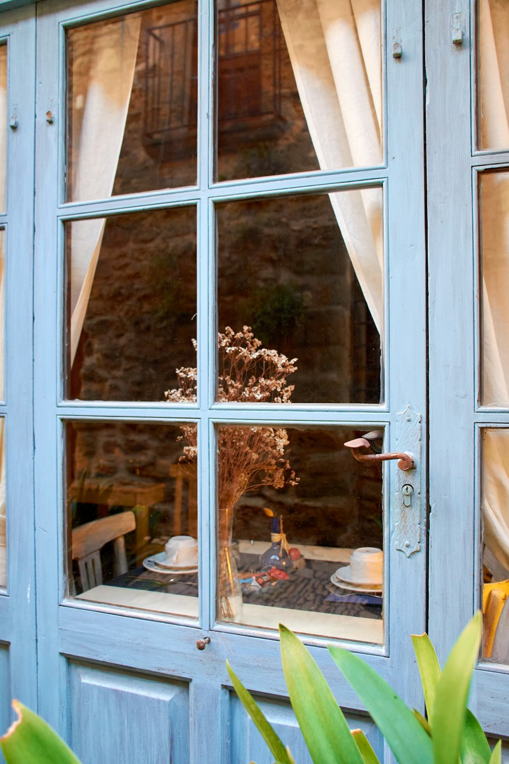 a window with a vase of flowers in it