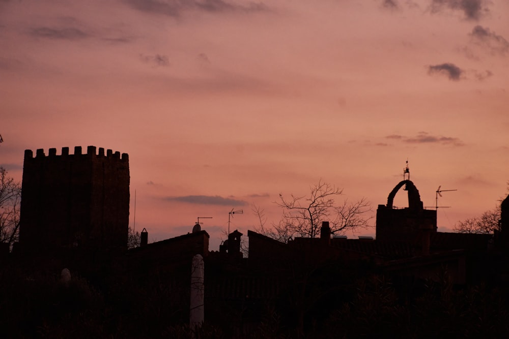 a silhouette of a building with a clock tower in the background