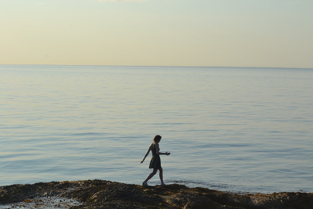 a person walking along the shore of a body of water