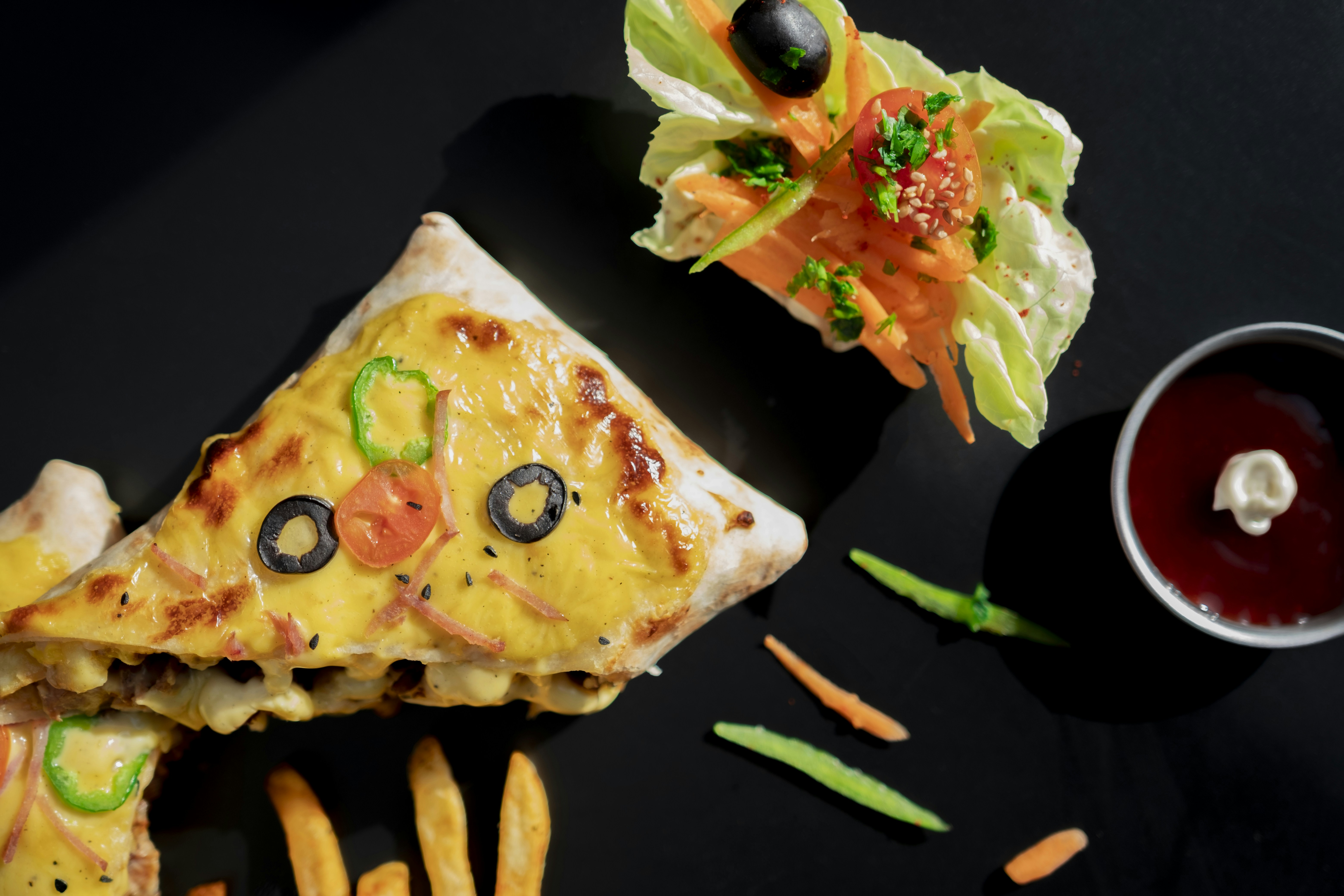 a slice of pizza on a plate with fries and ketchup