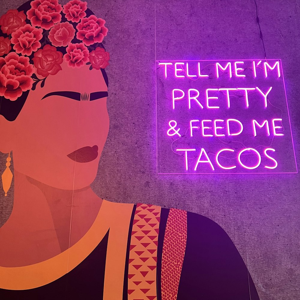 a neon sign that says tell me i'm pretty and feed me tacos