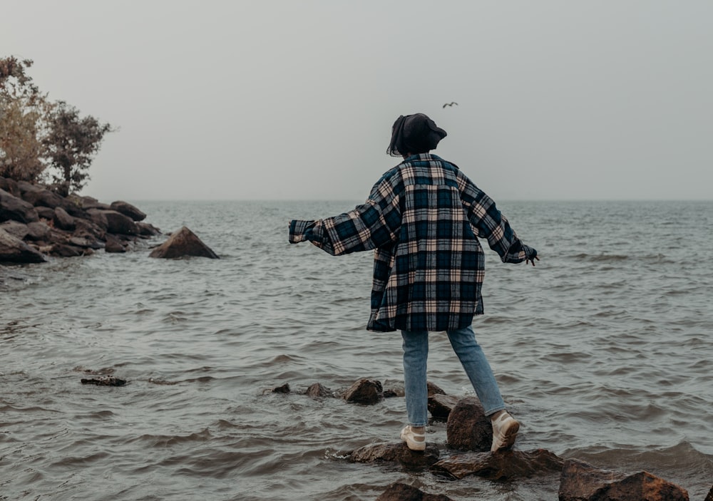 a person standing on rocks in the water