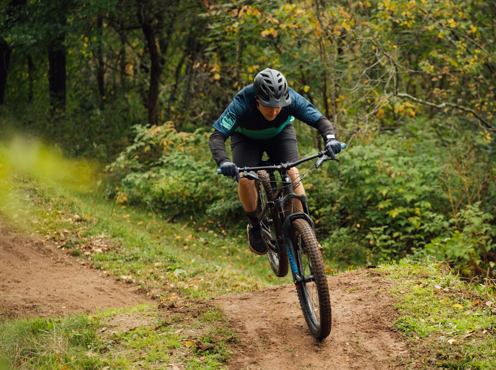 a man riding a bike down a dirt road