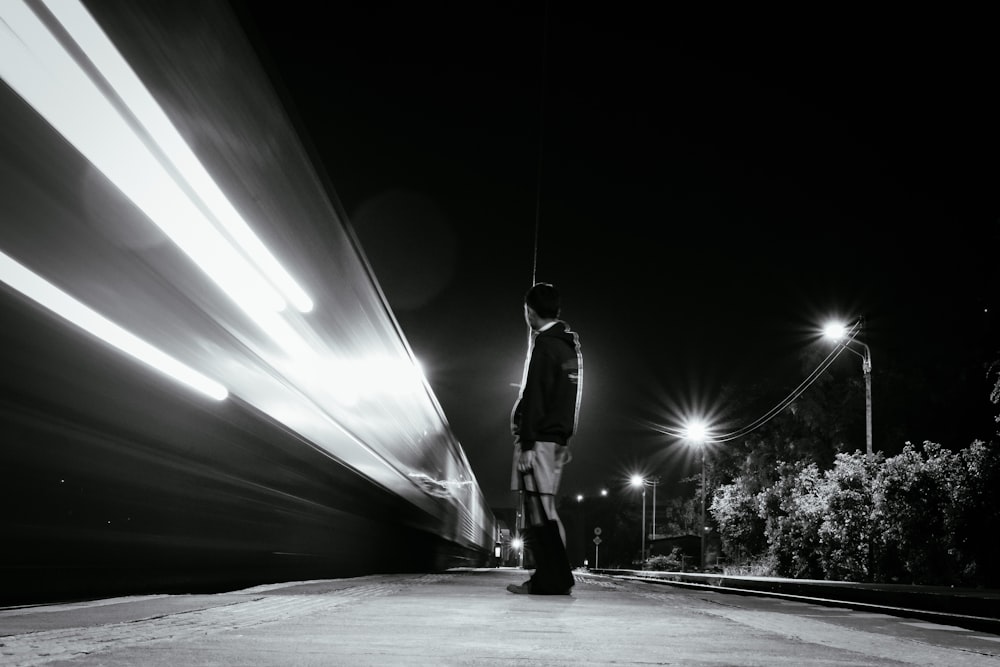 a man standing on the side of a road at night