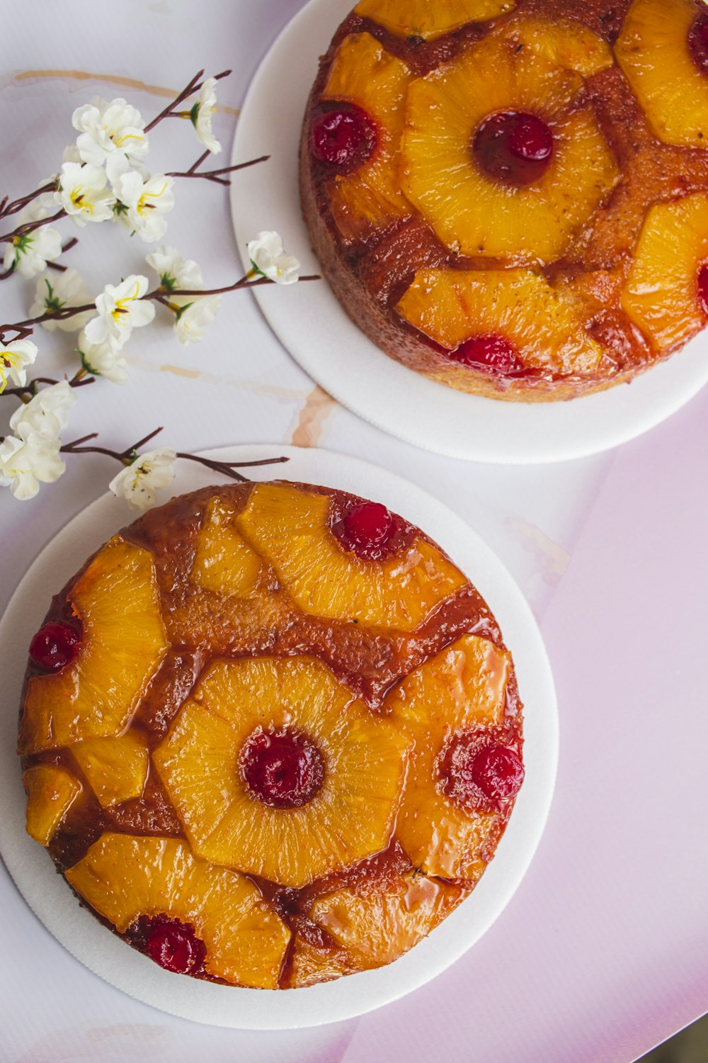 two pineapple upside down cakes sitting on a table