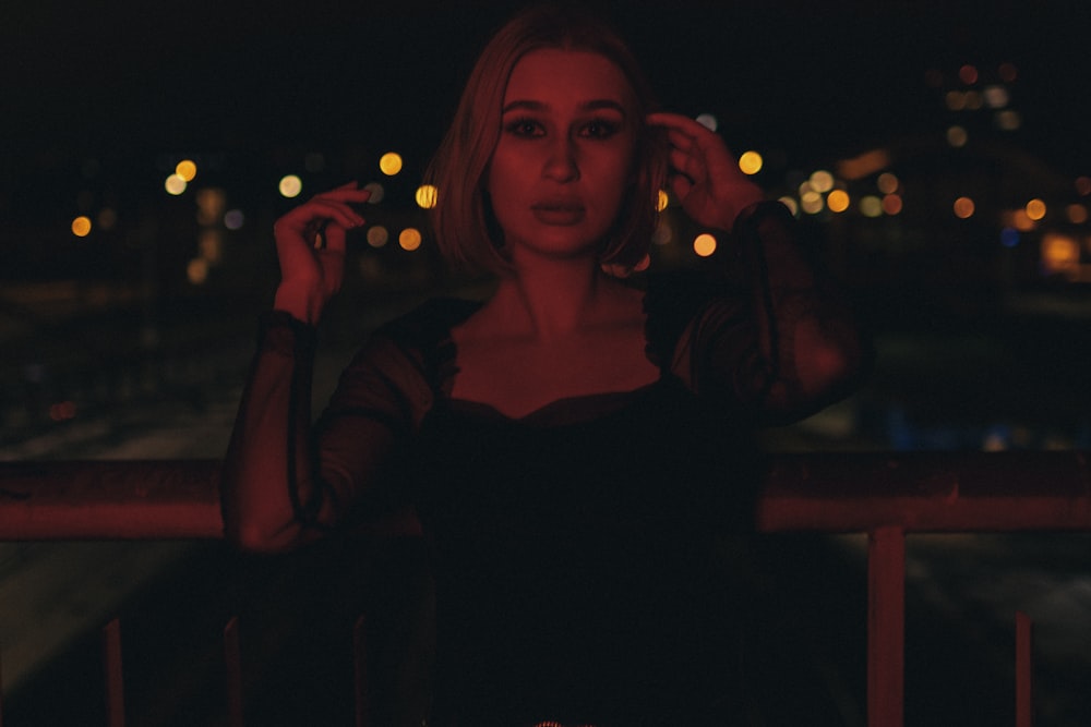 a woman standing on a balcony at night