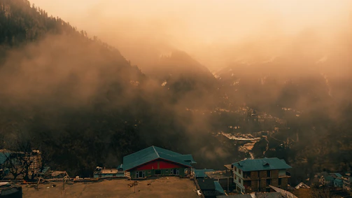 A misty morning view over the rolling hills of Albania with ancient stone villages nestled in the landscape.