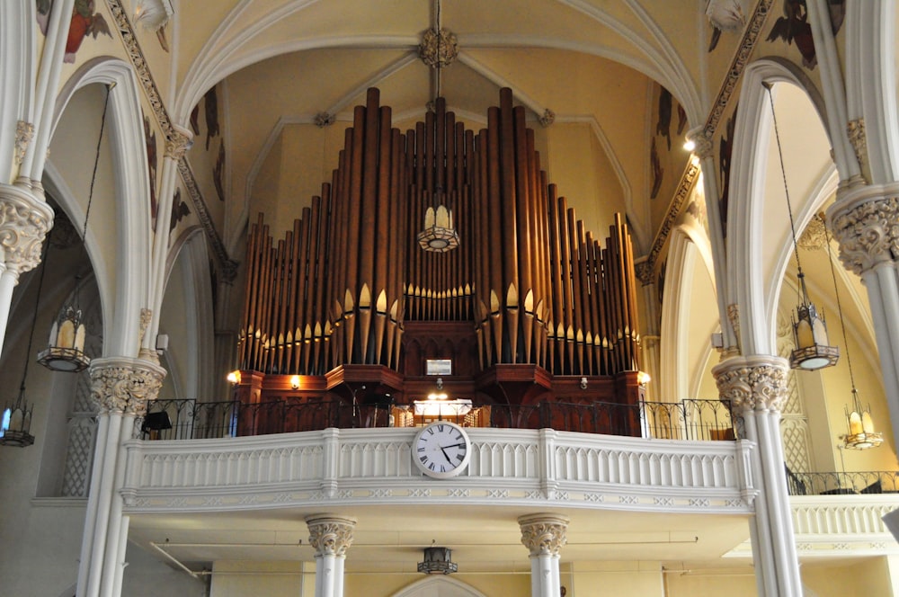 a large pipe organ in a church with a clock