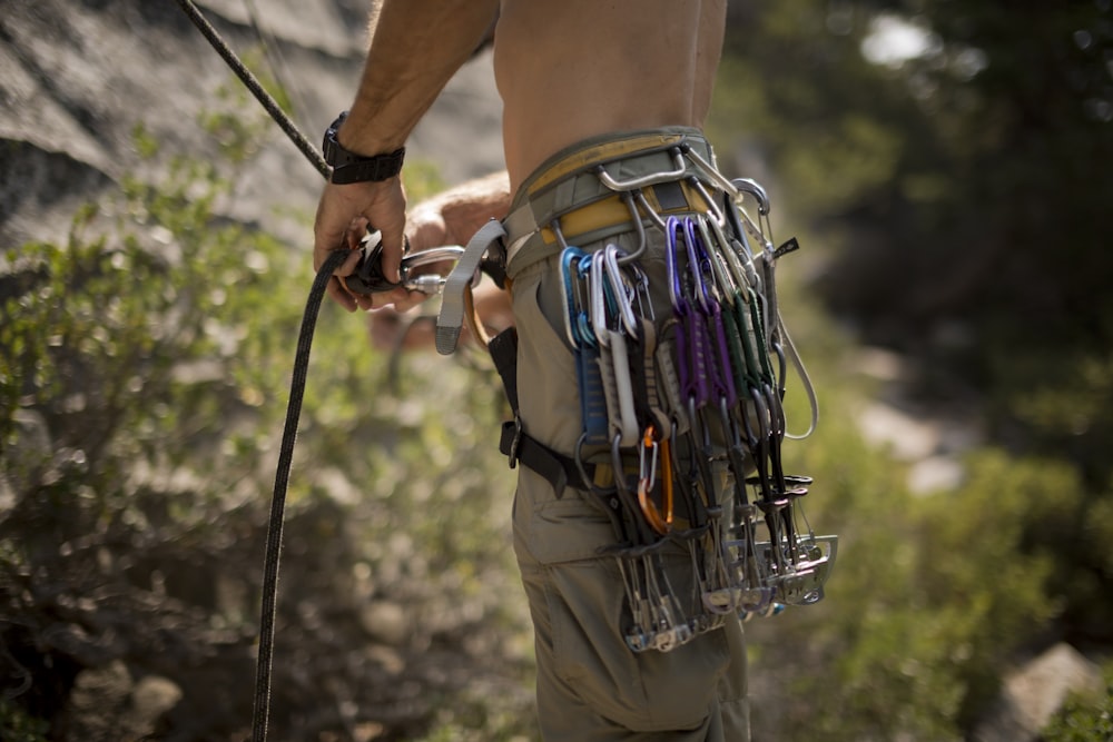 a man holding a bunch of scissors in his belt