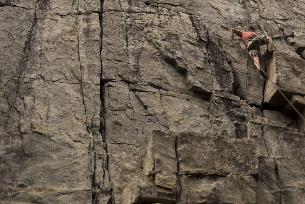 a man climbing up the side of a mountain