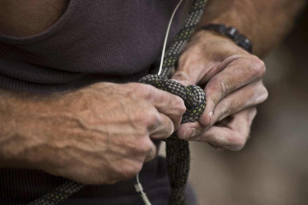 a close up of a person holding a rope