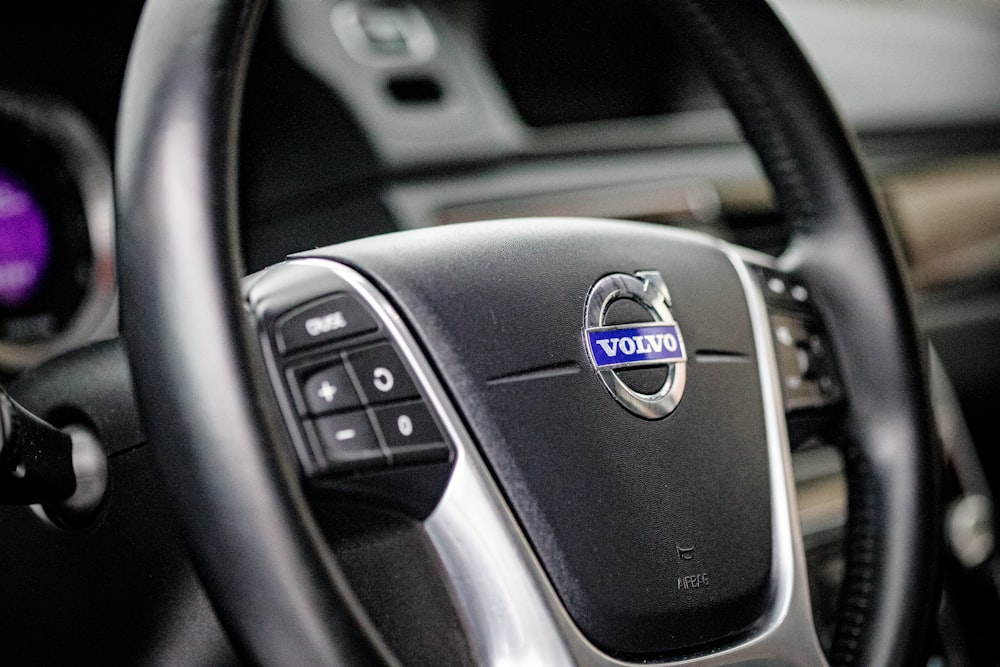 the steering wheel of a car with a volvo sticker on it