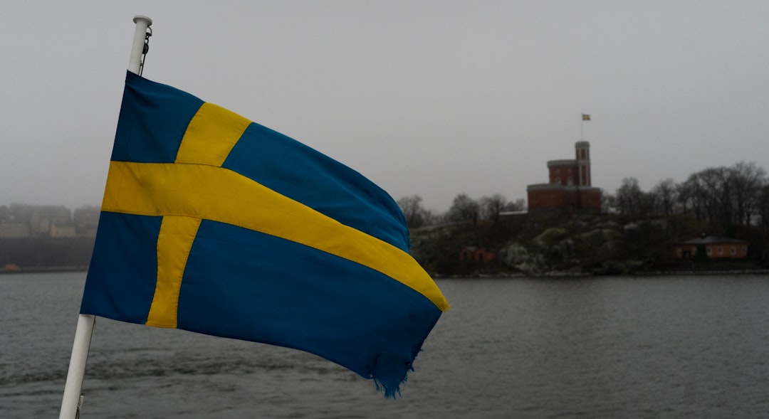 a blue and yellow flag flying over a body of water