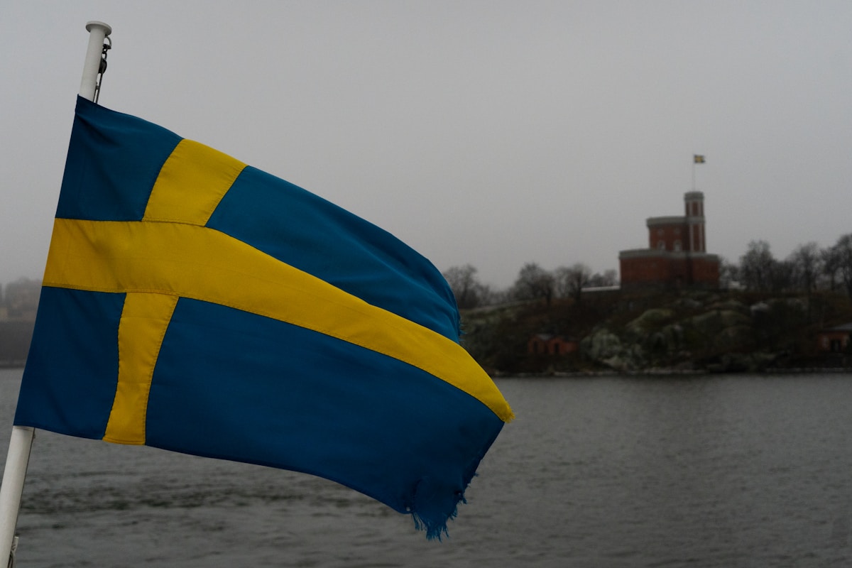 a blue and yellow flag flying over a body of water