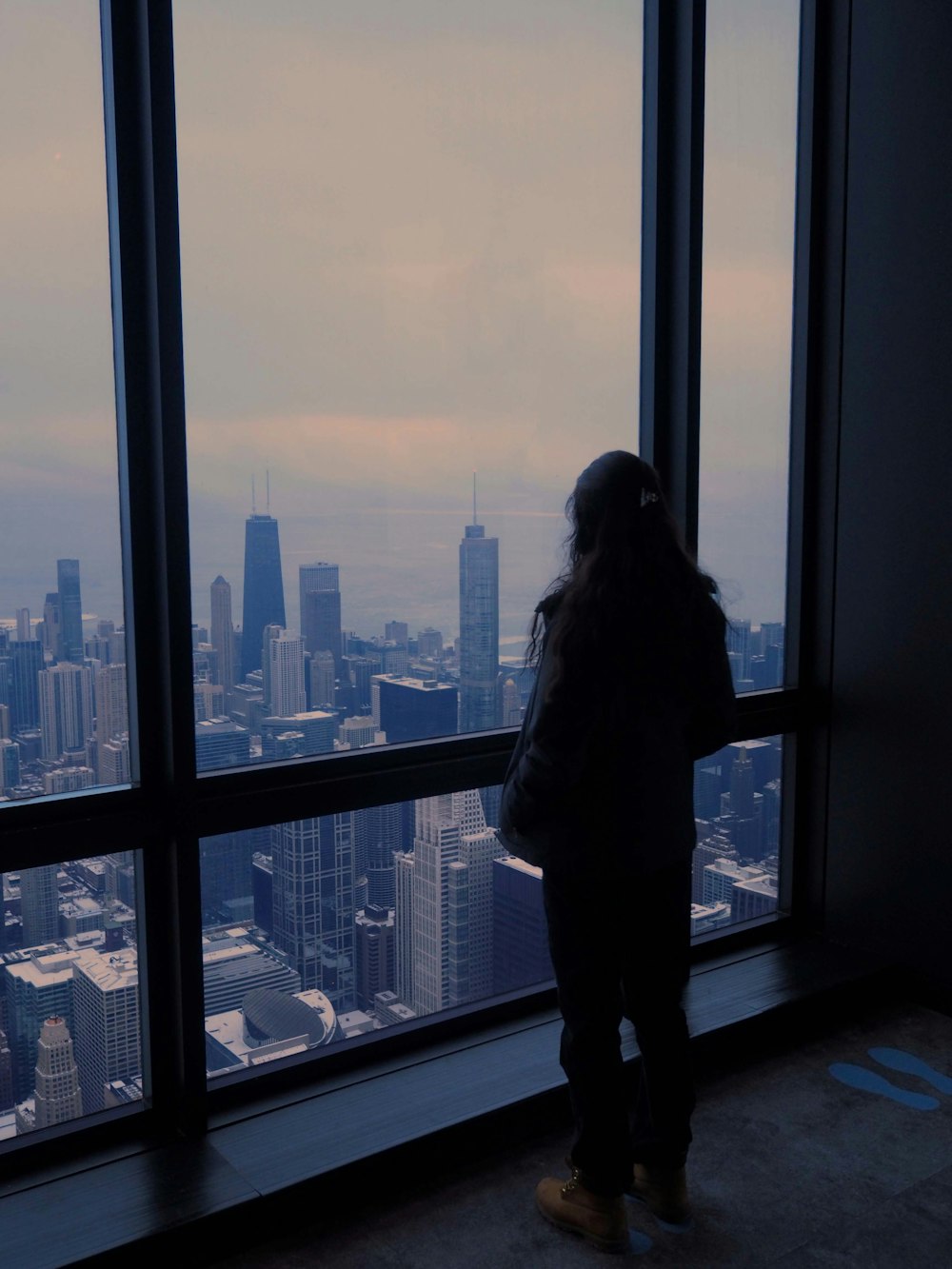 a person looking out a window at a city