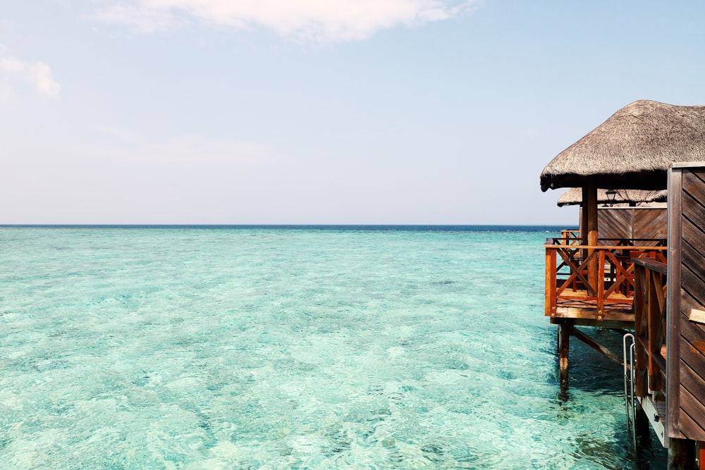 a house on stilts in the middle of the ocean