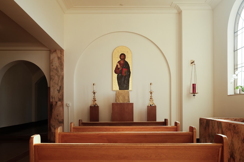 木製の会衆席と壁に絵が描かれた教会