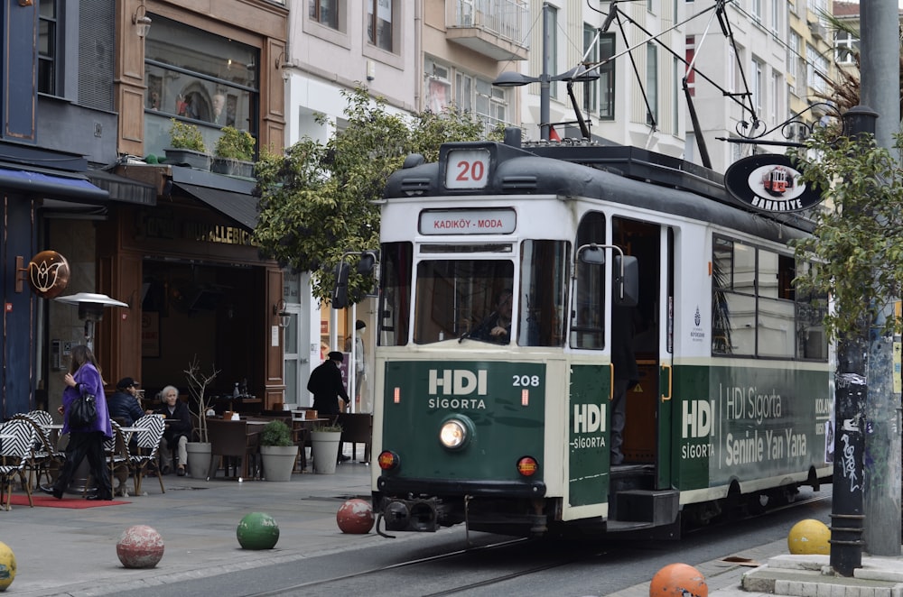 Un carrello verde e bianco su una strada della città