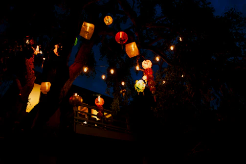 An outdoor patio illuminated by colorful, sparkling lanterns at night.