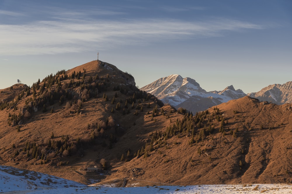 Una cadena montañosa con algunas montañas cubiertas de nieve al fondo