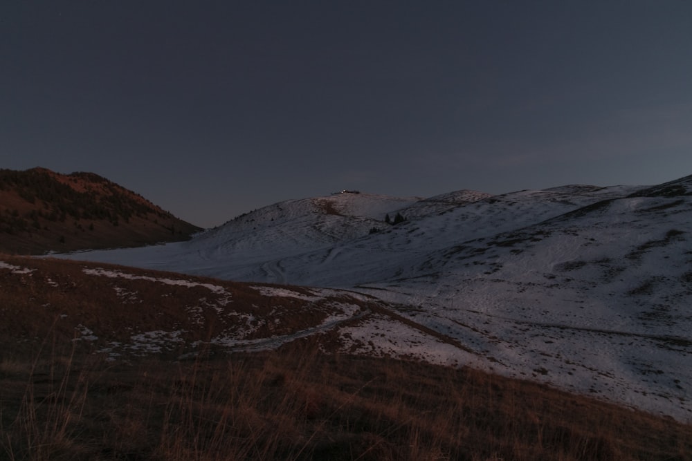 Une colline couverte de neige sous un ciel sombre