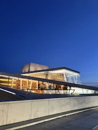 A sleek 3D-rendered modern building with glass facades glowing under soft evening light.