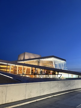 A sleek 3D-rendered modern building with glass facades glowing under soft evening light.