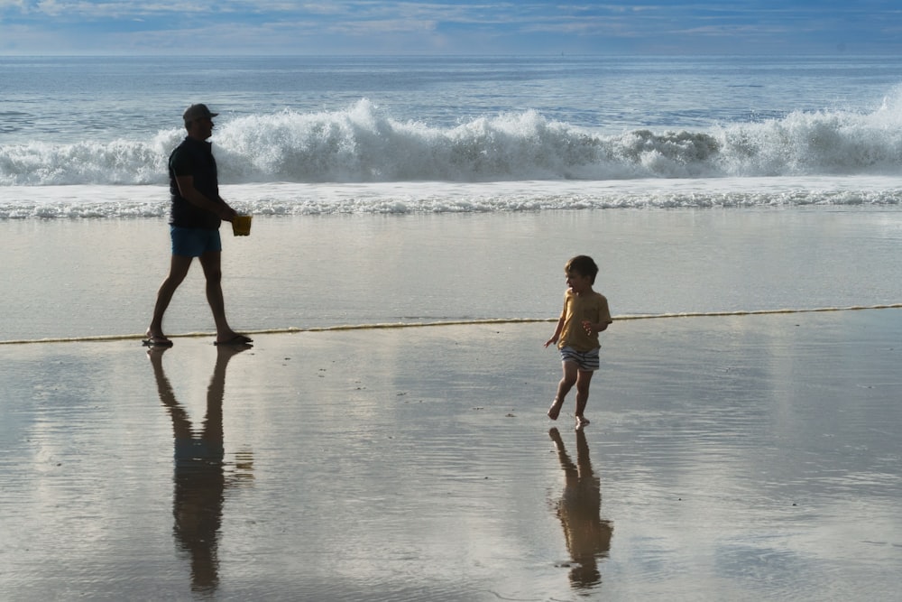a man and a small child walking on a beach