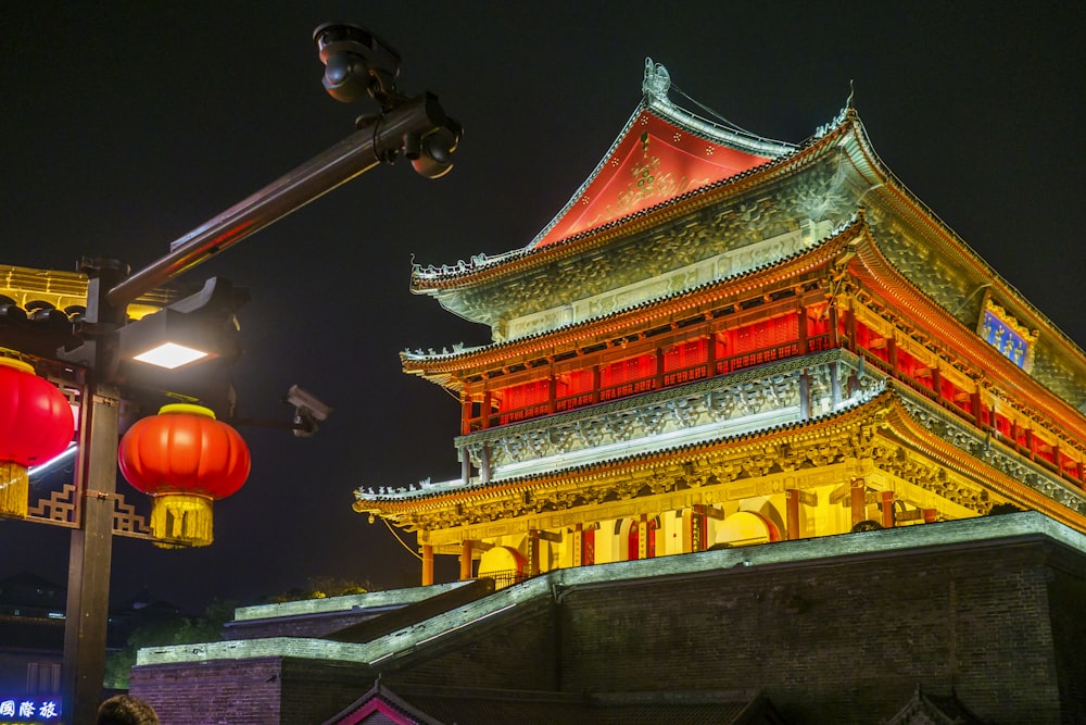 a chinese building lit up at night with red lanterns