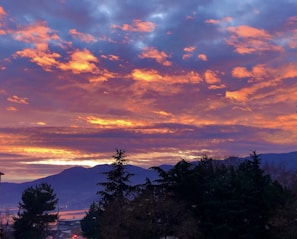 A stunning sunset over the rugged outback with silhouettes of distant mountains.