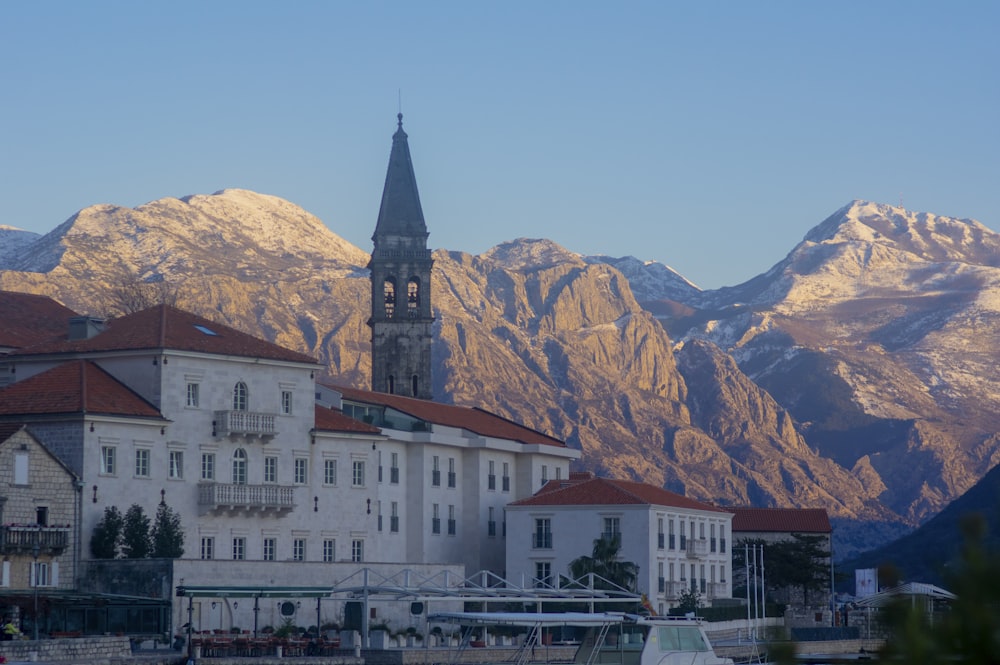 a large building with a steeple in front of a mountain range
