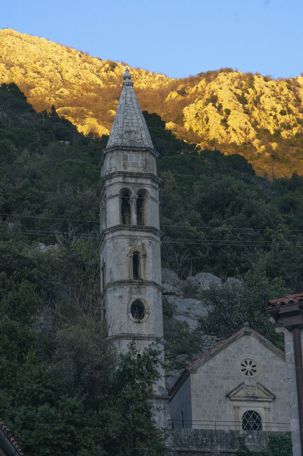 a church steeple with a mountain in the background
