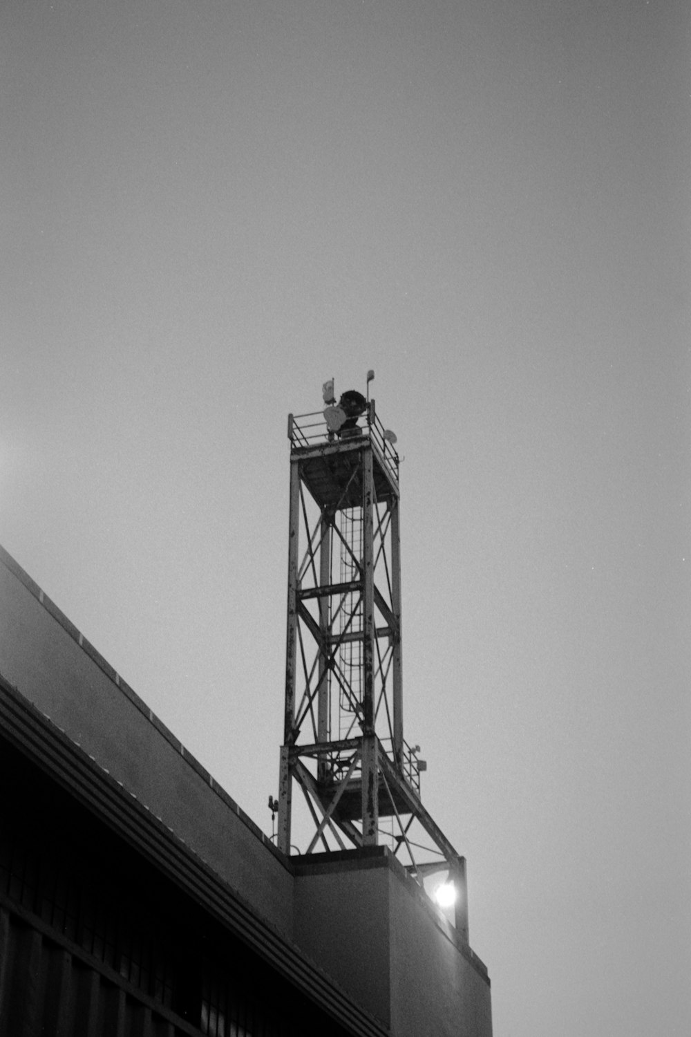 a black and white photo of a tower on top of a building
