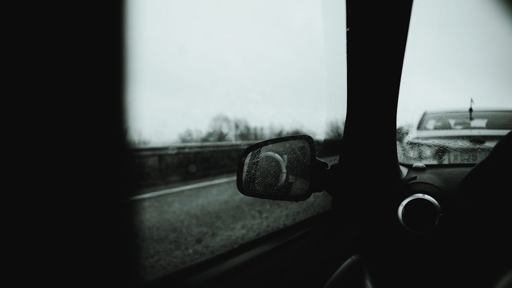 a rear view mirror of a car on a road